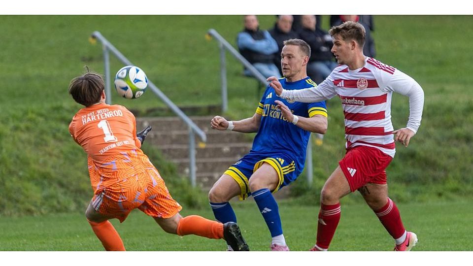 Wommelshausen/Dernbachs Fabian Staus (M.) kommt zu spät. Hartenrods Torwart Janne Matti Pfeiffer und Jonathan Gräb klären mit vereinten Kräften. 2:2 geht das Duell in der Fußball-Kreisliga A Biedenkopf aus. © Lars Hinter