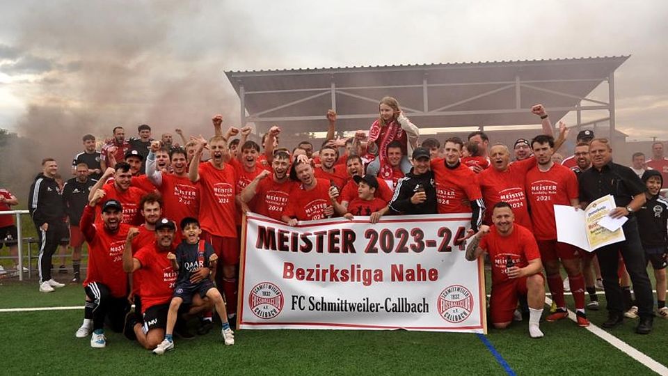 Durch einen Kantersieg in Planig sicherte sich der FC Schmittweiler/Callbach den Titel in der Fußball-Bezirksliga Nahe: Mit FC-Vorstand und zahlreichen Fans freuen sich die Hauptakteure des 30. Spieltages: Lucas Frenger, Christian Rech, Aurel Rech, Yannick Naujoks, Justus Rech, Leon Frenger, Marius Heimann, Jeffrey Renner, David Atama, Dennis Köhler, Simon Scherer, Jakob Thilo Hill, Sascha Frenger, Niklas Paulus, Petrit Miftari, Lukas Kaul, Leon Hübner, Fabian Boppel und natürlich Trainer Murat Yasar. 	Foto: Heidi Sturm