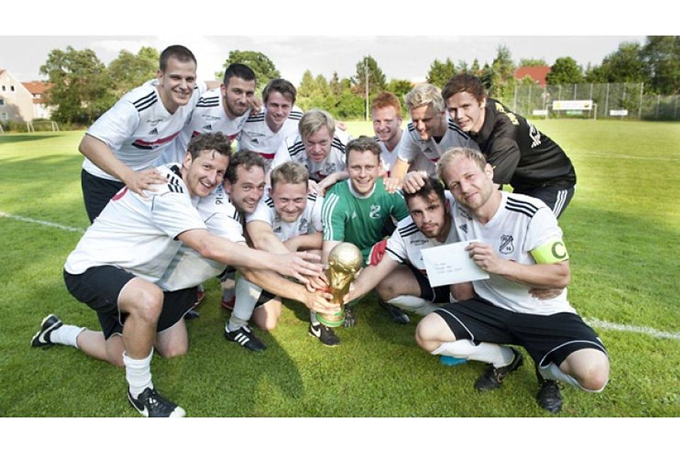 Weiße Trikots, goldener Pokal: Der SV 16 bejubelt den Turniersieg mit einer Replik der WM-Trophäe. Foto: Hülsmann