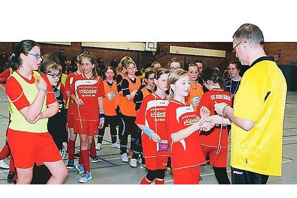 Konrad Focken (r.) von der Jugendabteilung gratuliert den Sedelsberger D-Mädchen und händigt allen Fußballerinnen eine Plakette aus. Wilhelm Hellmann