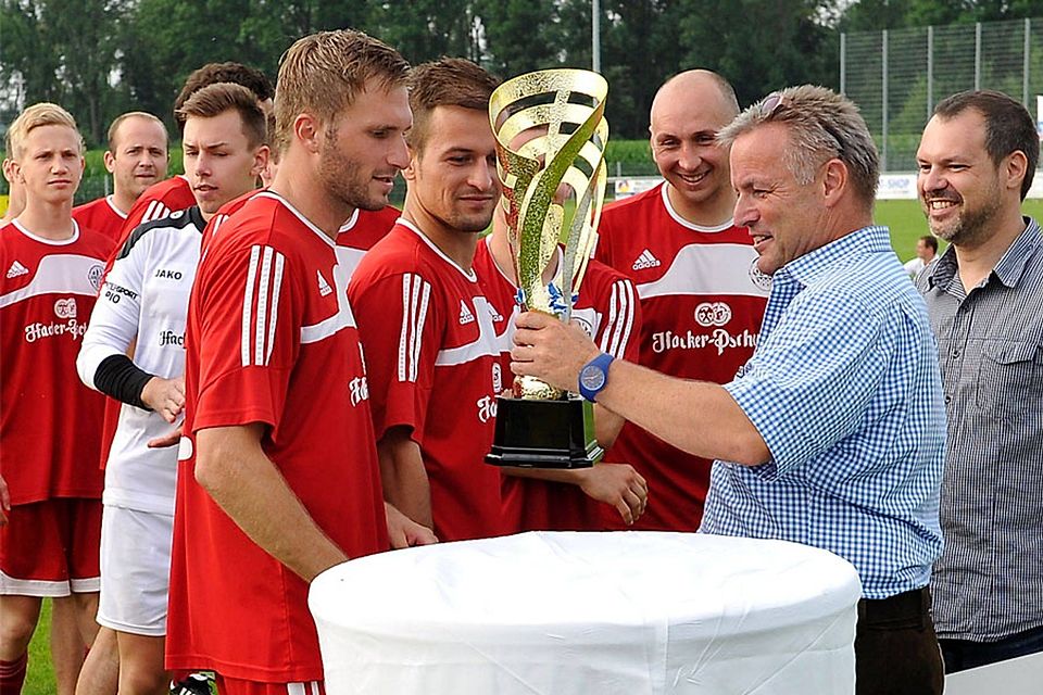 Vorstandsvorsitzender Stefan Jörg (zweiter von rechts) und Manfred Doll (rechts) von der VR-Bank überreichen dem Landkreismeister TSV Landsberg den Pokal.	F.: Thorsten Jordan