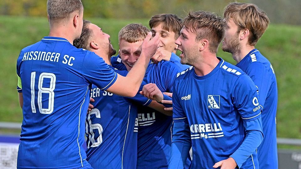 Torschütze Leon Seiler in der Mitte und seine Teamkameraden des Kissinger SC jubeln über den knappen Sieg gegen den TSV Göggingen.