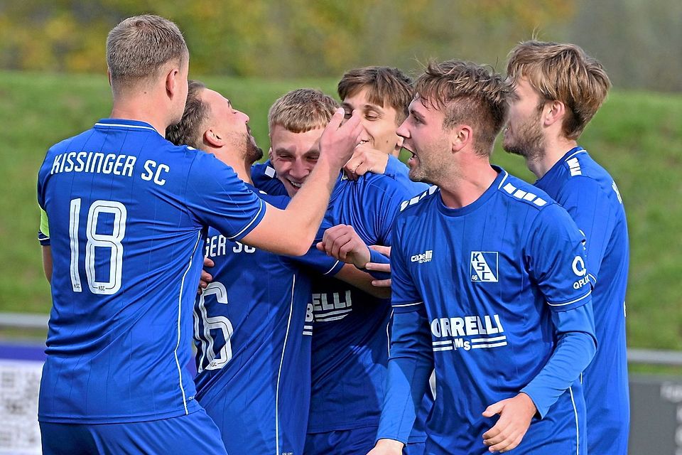 Torschütze Leon Seiler in der Mitte und seine Teamkameraden des Kissinger SC jubeln über den knappen Sieg gegen den TSV Göggingen.