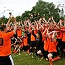 Im vergangenen Jahr in Meckelstedt war es eine Feiersause in orange: Fabian Behnke, Kapitän der Ersten der SG Frelsdorf/Appen/Wollingst, reckt den NZ-Pokal in die Höhe. Die Spieler beider SG-Mannschaften, die sich im Finale gegenüberstanden, jubeln gemeinsam. Foto Scheschonka