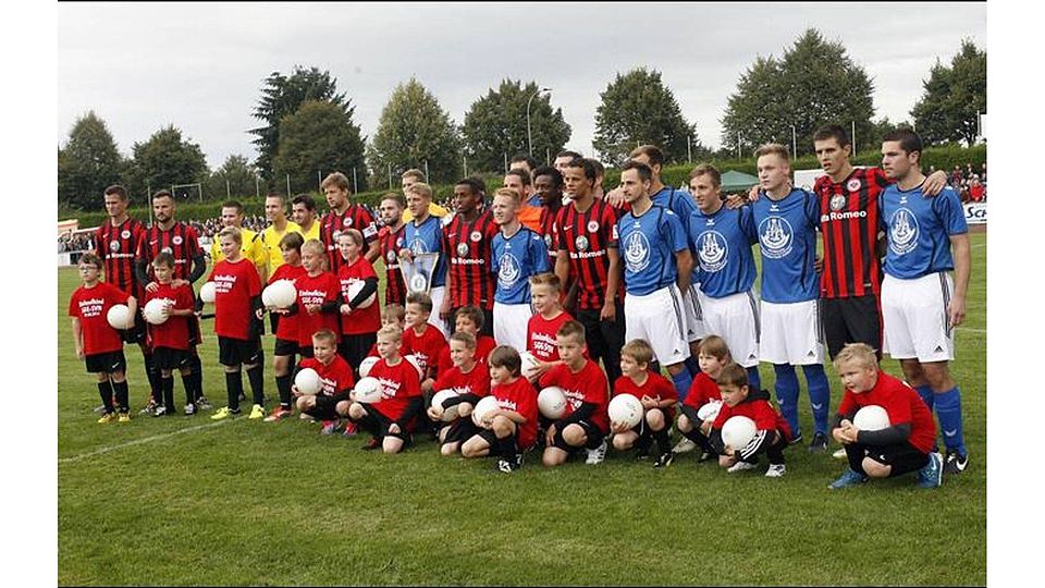 Amateure freuen sich mit Profis: Die Hungener Stadtauswahl und die Frankfurter Eintracht nehmen vor dem Freundschaftsspiel Aufstellung. Foto: Ben