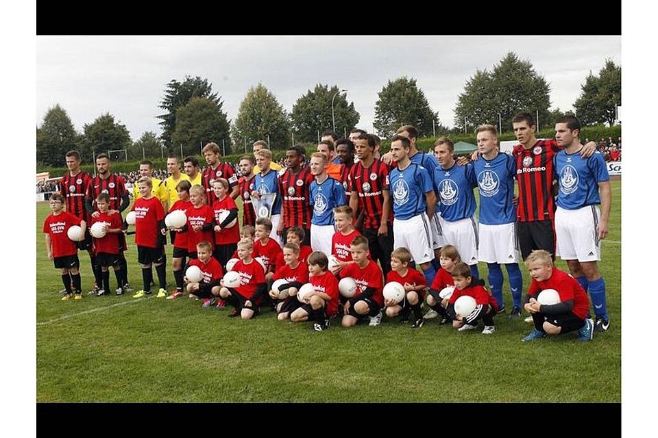 Amateure freuen sich mit Profis: Die Hungener Stadtauswahl und die Frankfurter Eintracht nehmen vor dem Freundschaftsspiel Aufstellung. Foto: Ben