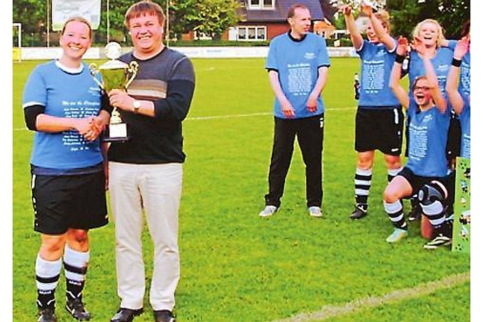 Staffelleiter Ralf Busse überreicht Ann-Katrin Spille, Kapitänin SW Linderns, den Pokal für die Meisterschaft in der Fußball-Kreisklasse Nord. NFV