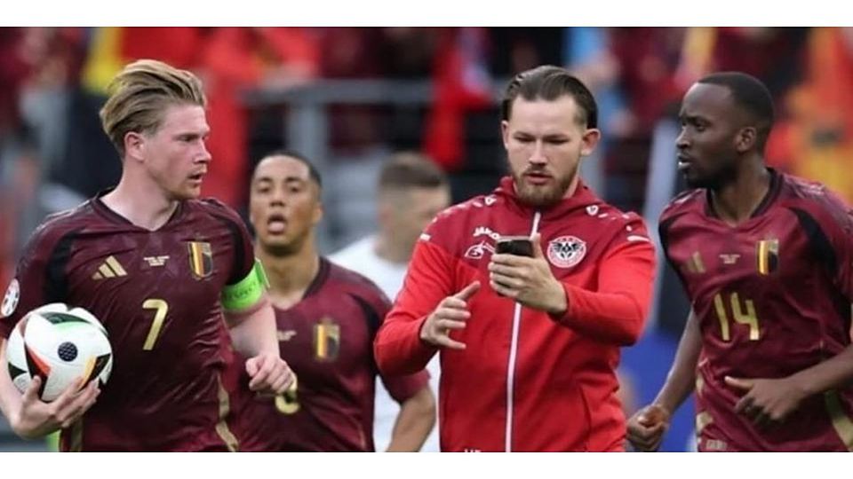 Die belgischen Nationalspieler sind perplex, als beim EM-Vorrundenspiel in Frankfurt gegen die Slowakei zwischen ihnen ein „Flitzer“ im Spartak-Wetzlar-Outfit auftaucht. © Screenshot: Instagram sergej_st97