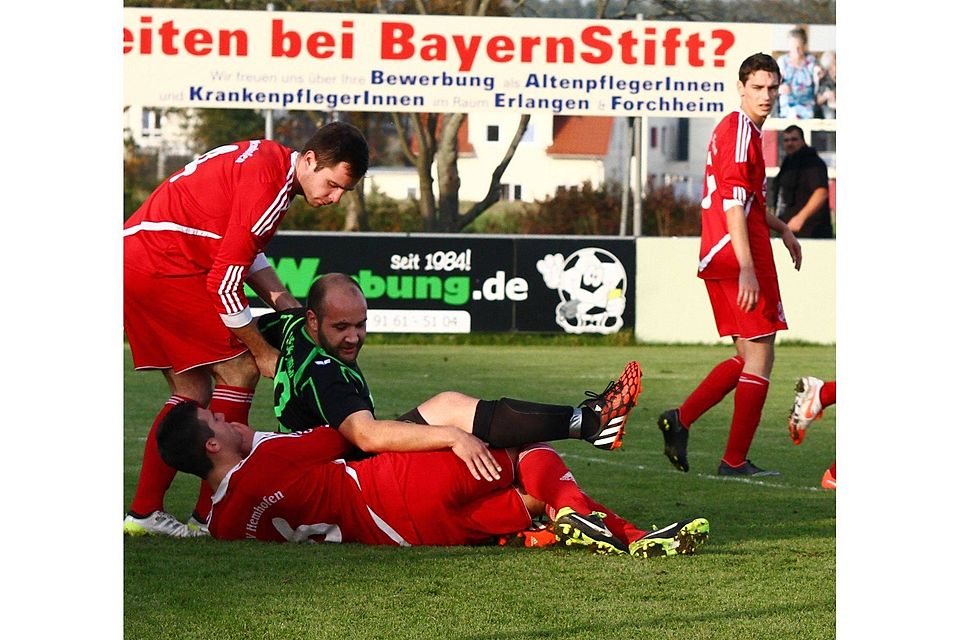 So wie in dieser Szene des Spiele gegen Hertha Aisch wollen die Spieler des TSV Hemhofen (in Rot) nach der Partie gegen den ASV Weisendorf II auch übereinander fallen. Dann allerdings, um zu Jubeln. Foto: Spörlein