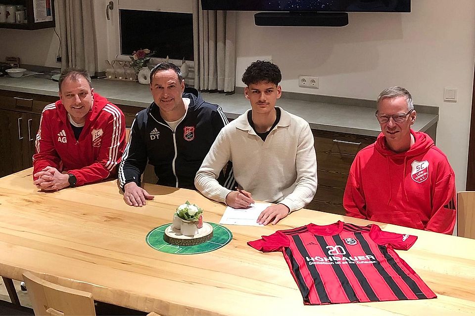 Neuzugang Arian Miftaraj (Zweiter von rechts) bei der Vertragsunterschrift im Sportheim des SC Luhe-Wildenau.