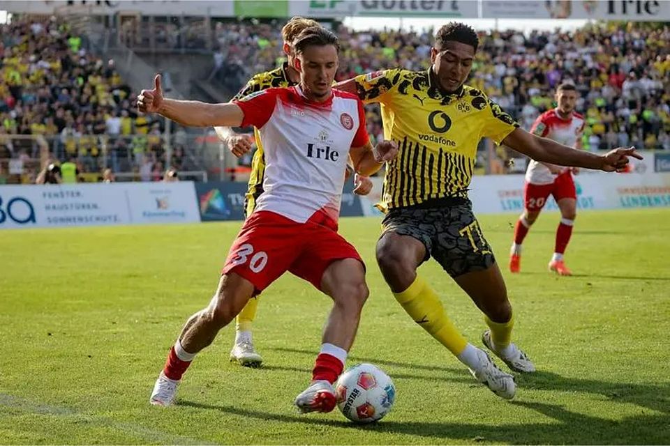 Dustin Willms (li., Sportfreunde Siegen) macht gleich Bekanntschaft mit Borussia Dortmunds Neuzugang Jobe Bellingham. © Jonathan Ortmann