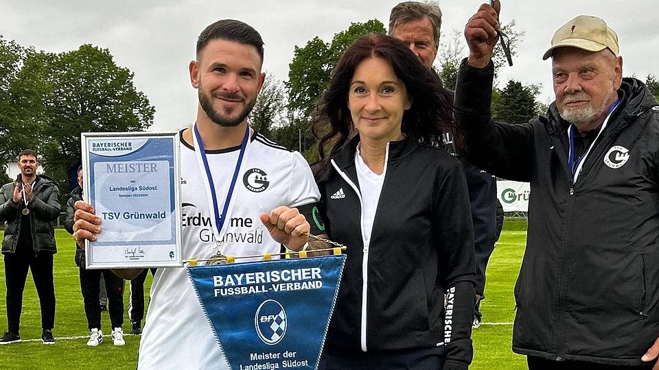 Gemeinsam mit Spielgruppenleiterin Simone Petzke präsentiert Grünwalds Kapitän Marco Bornhauser Urkunde und Wimpel für die Landesliga-Meisterschaft.