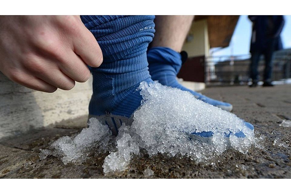 Ein Neustädter Spieler kühlt seine Verletzung am Fuß mit dem beiseite geräumten Schnee. Er war also doch für was gut. | Foto: Patrick Seeger