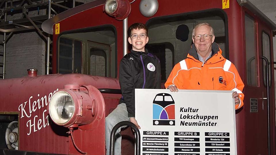 Glücksfee Finn und Turniersponsor Dr. Thomas Kittel machen es sich auf der historischen Lokomotive „Kleiner Helmut“ bequem.