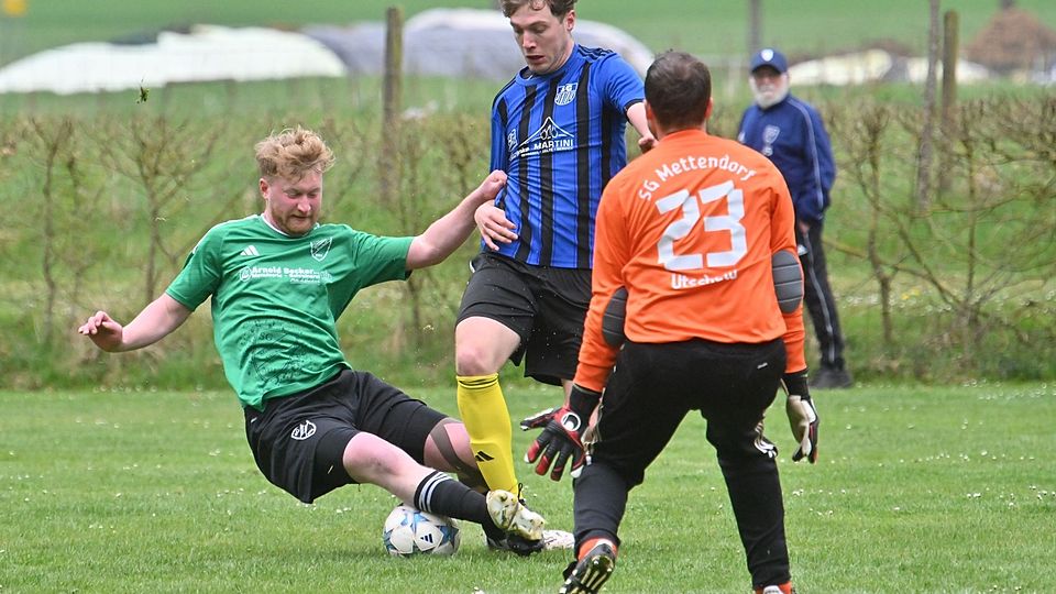 Kampf und Einsatz waren Trumpf im Duell der beiden abstiegsbedrohten Teams. Hier grätscht Utscheids Thomas Müller den Ball vor Dhrontals Danny Schömer weg. Keeper Oliver Fuchs muss nicht mehr eingreifen. Aufmerksamer Beobachter im Hintergrund: Josef Scholtes, die Utscheider Vereinslegende.