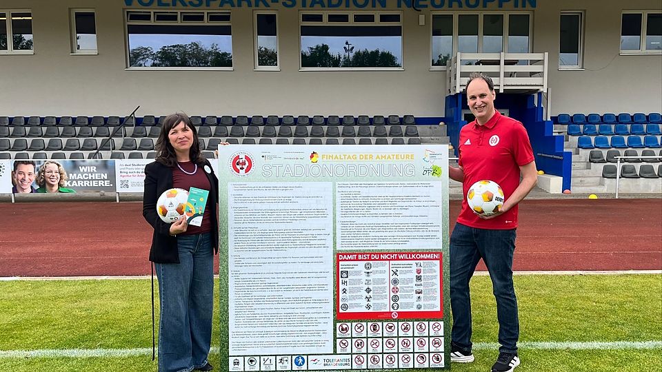 Julica Norouzi (Landkreis Ostprignitz-Ruppin) und FLB-Veranstaltungsleiter Martin Hagemeister-Kühn präsentieren die neue Stadionordnung.
