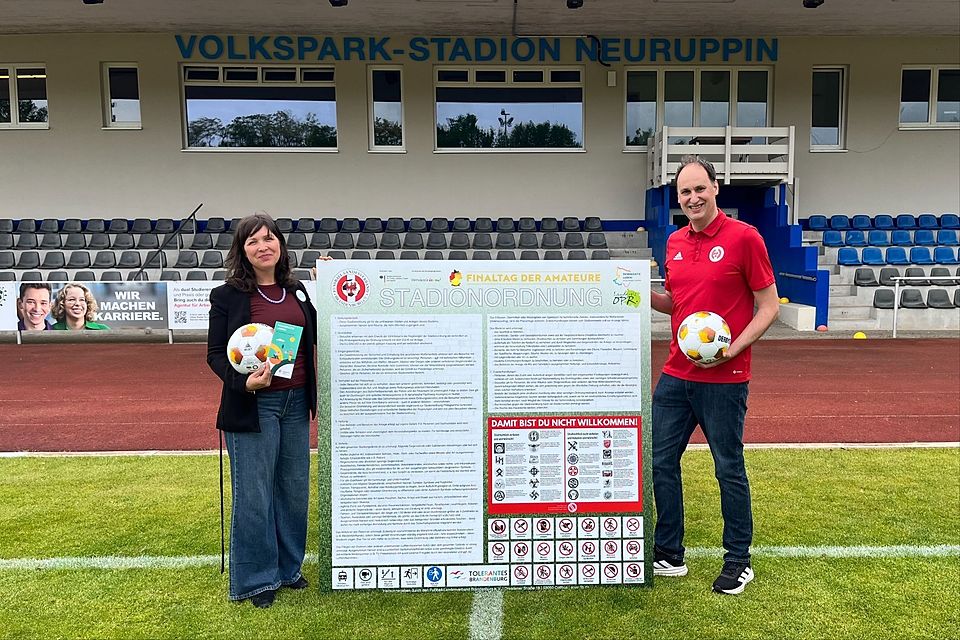 Julica Norouzi (Landkreis Ostprignitz-Ruppin) und FLB-Veranstaltungsleiter Martin Hagemeister-Kühn präsentieren die neue Stadionordnung.