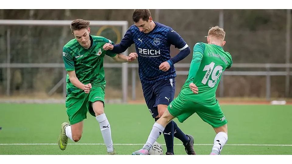 Szene aus der Partie SG Eschenburg II - FC Niederrossbach: Der Eschenburger Bastian Reiprich (Mitte) versucht, zwischen Lenni Wohlrab (l.) und Anfernee Hof durchzukommen. © Jonathan Ortmann