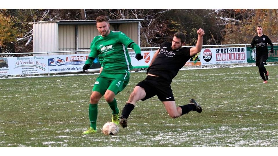 Die SG Altenburg/Eudorf/Schwabenrod erkämpft gegen Lang-Göns noch ein 1:1. Hier rettet Julian Kraft gegen Daniel Träger. (© Luca Raab)