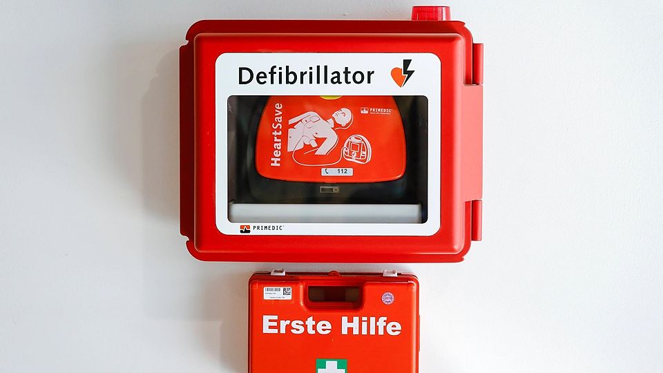 09.04.2020, Duesseldorf, Nordrhein-Westfalen, Deutschland - Defibrillator und Erste Hilfe Verbandskasten haengen an einer Wand.