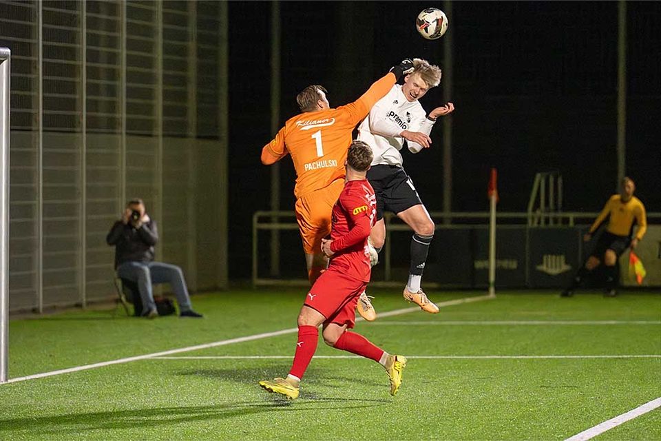 Hendrik Fleige (Heider SV) kommt nicht zum Kopfball - Keeper Tom Pachulski boxt das Spielgerät aus der Gefahrenzone.