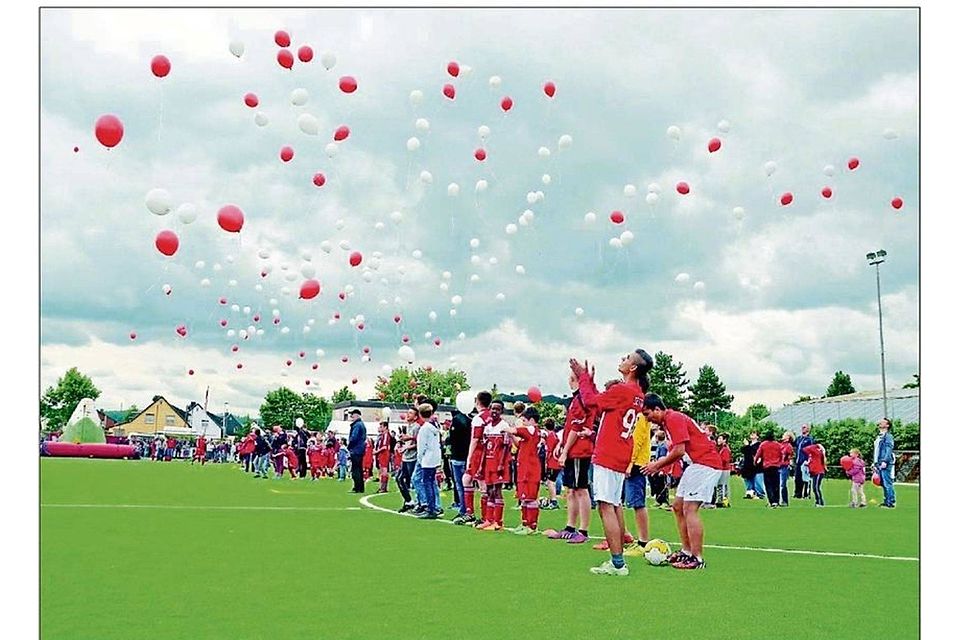 Luftballons lassen die Spieler des Rot-Weiß Lessenich zur Eröffnung des Kunstrasenplatzes fliegen. FOTO: STEFAN KNOPP