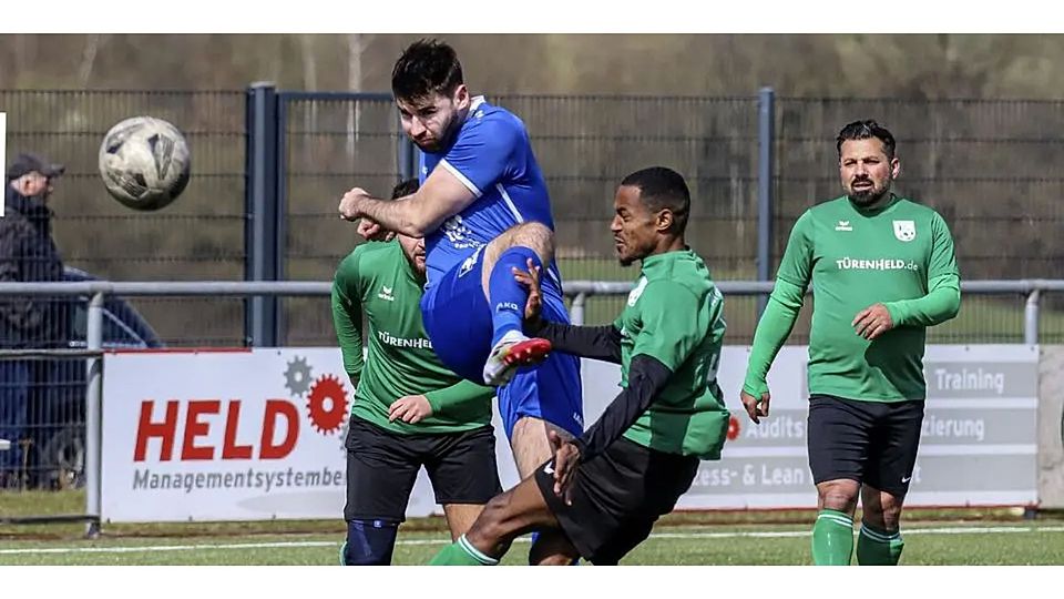 Langenaubachs Spielender Co-Trainer Timo Strassen haut den Ball mit Wucht weg. Im Vordergrund wird er vom Dillenburger Gedu Fikadu angelaufen. © Lorenz Pietzsch