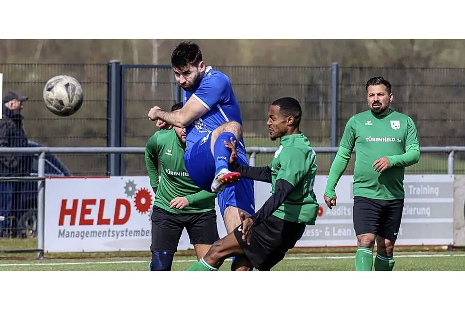 Langenaubachs Spielender Co-Trainer Timo Strassen haut den Ball mit Wucht weg. Im Vordergrund wird er vom Dillenburger Gedu Fikadu angelaufen. © Lorenz Pietzsch