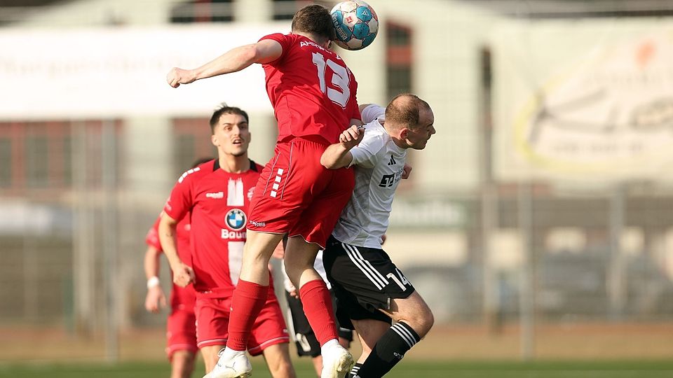 Kopfballduell mit Zuschauer im Hintergrund: Matthias Burg (SG Hochwald Zerf/in weiß) im Luftkampf mit  Ahrweilers Paul Bermel