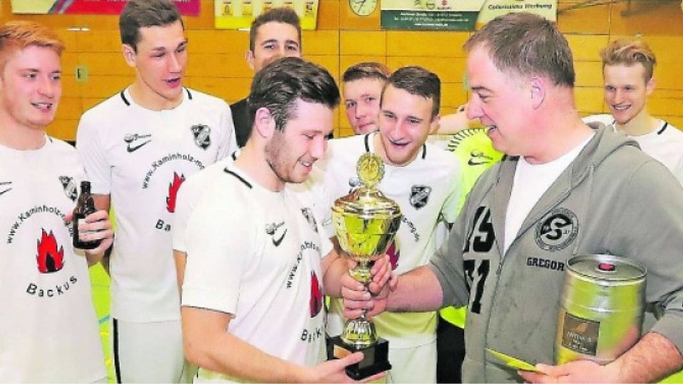 Lohn für einen überraschenden Turniersieg: Die Kicker des Gladbacher Bezirkligisten Viktoria Mennrath erhalten den Pokal. Foto: Royal