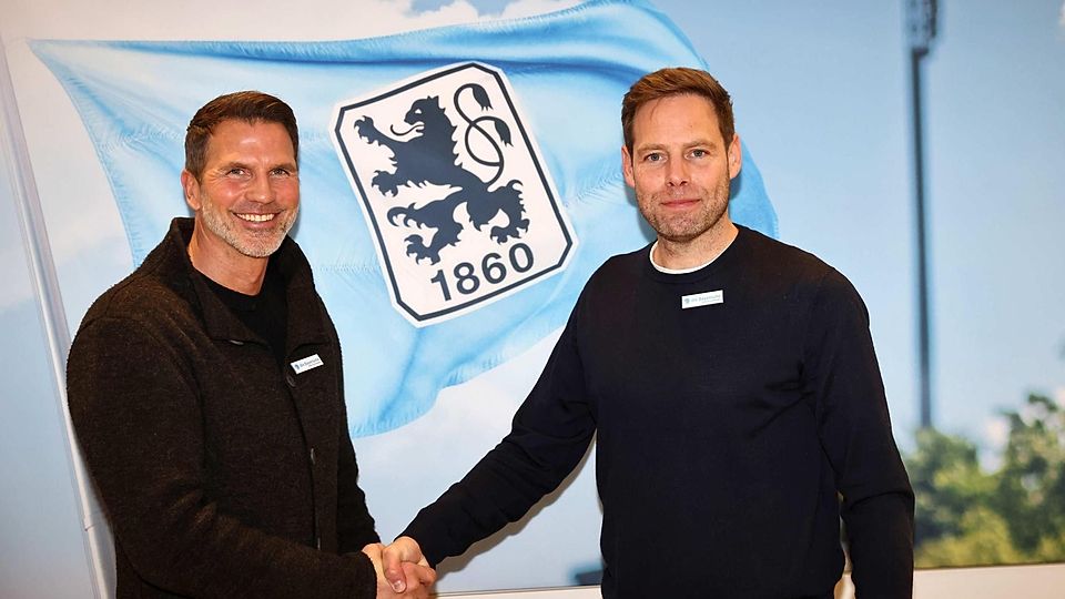 Zwei Männer reichen sich vor dem Wappen des TSV 1860 München die Hand
