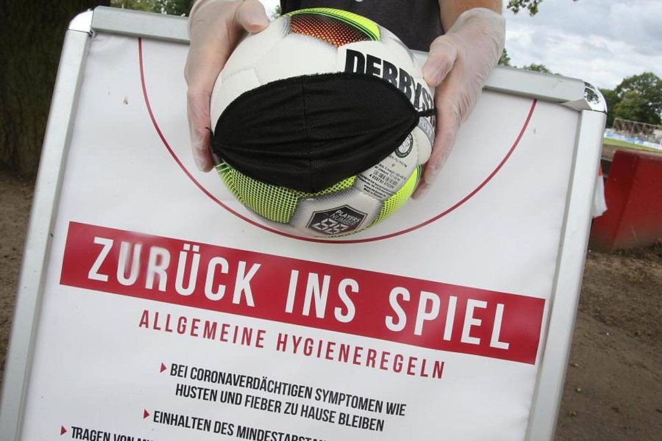Ball mit Mund-Nasenschutz, gehalten mit Einmalhandschuhen: Der Fußball 2020 hat seine eigenen (Hygiene-)Regeln.	Foto: Bär