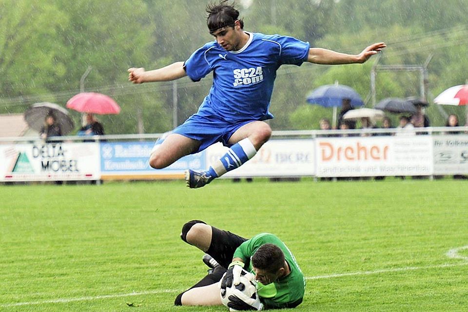 Höhenflug im strömenden Regen: Wiesenbachs Steffen Brennig springt fair über den Meitinger Schlussmann Emrah Yaman, der den Ball gesichert hat.  F.: E. Mayer