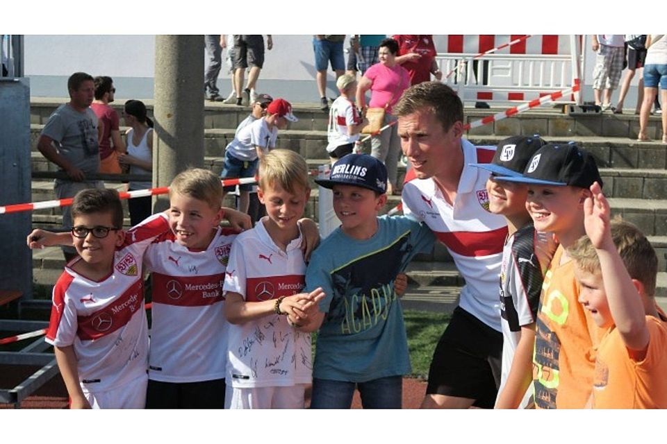 VfB-Trainer Hannes Wolf machte nicht nur diese sieben jungen Fans glücklich. Mehr als eine halbe Stunde nach Spielende stellte er sich immer noch geduldig für Selfies auf und erfüllte Hunderte Autogrammwünsche. Foto: Michael Ströbel