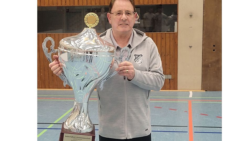 Reinhold Ackermann präsentiert den Siegerpokal der Hallenkreismeisterschaft. 