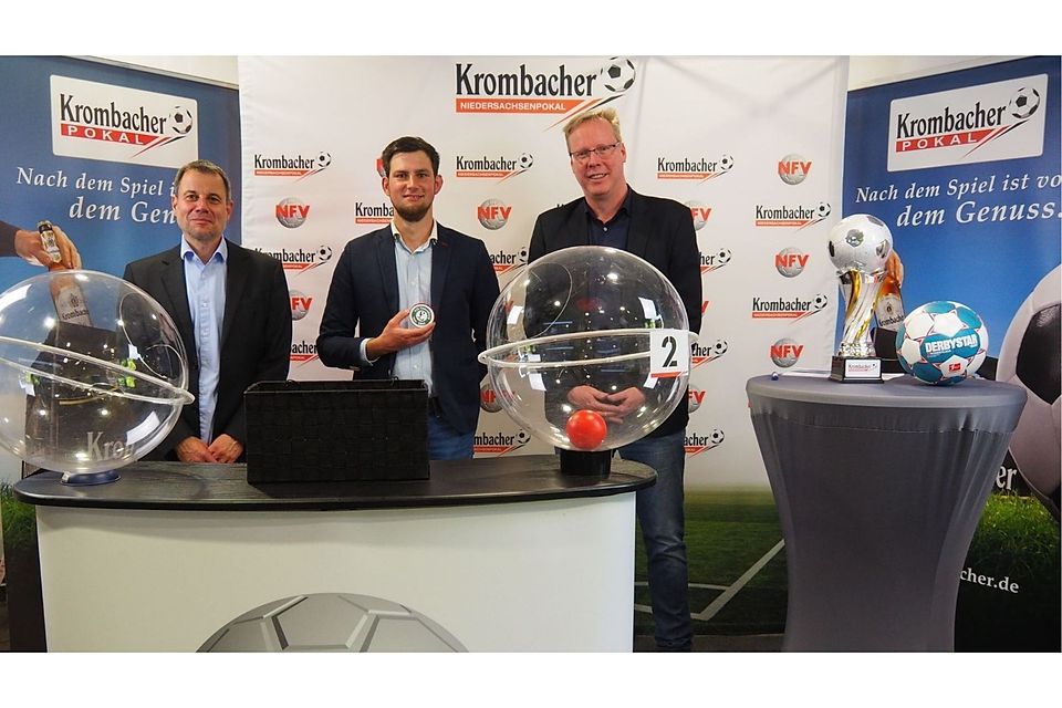 Simon Munaretto, Repräsentant der Krombacher Brauerei, präsentiert das von ihm gezogene Siegerlos VfL Oldenburg. Links NFV-Teamleiter Helge Kristeleit, rechts NFV-Pressesprecher Manfred Finger. 