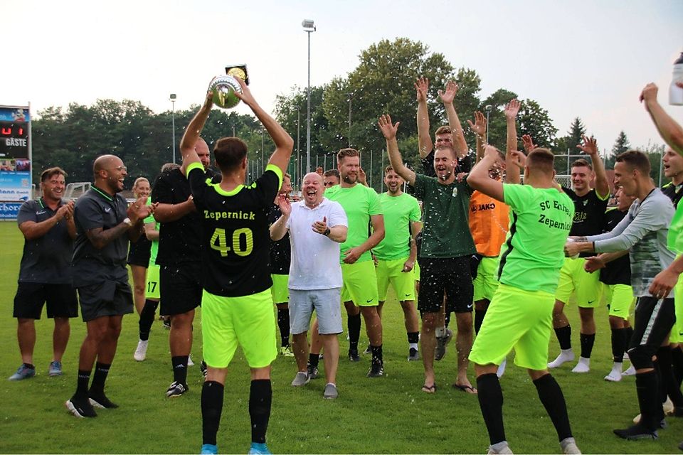 "Wir haben den Pott": Die Mannschaft von Einheit Zepernick feiert den ersten Pokalgewinn des Fußballkreises in der Vereinsgeschichte im Anschluss ausgelassen auf dem Rasen.
