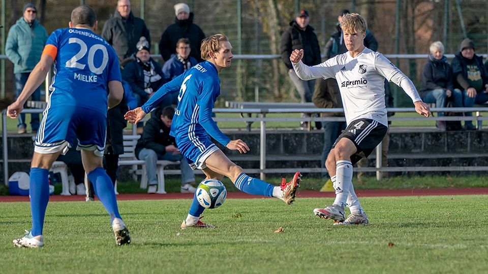 Tarek von Böhlen (Heider SV) spielt einen Pass durch die Kette der Oldenburger. Heinrich Lunau kommt nicht mehr an den Ball.
