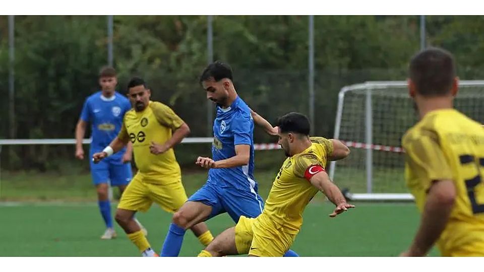 Einer der wenigen, die den FC Aksu Diyar Mainz nicht verlassen: Riza Can Coban (in blau) im Duell gegen den grätschenden Ataspor-Kapitän Oguz Akcesme.