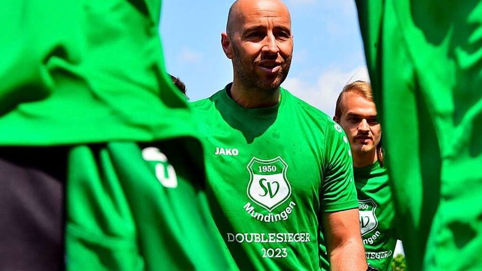 Karsten Bickel, der Trainer des SV Mundingen, im Kreise seiner Spieler mit dem eigens bestellten „Doublesieger“-Shirt. 