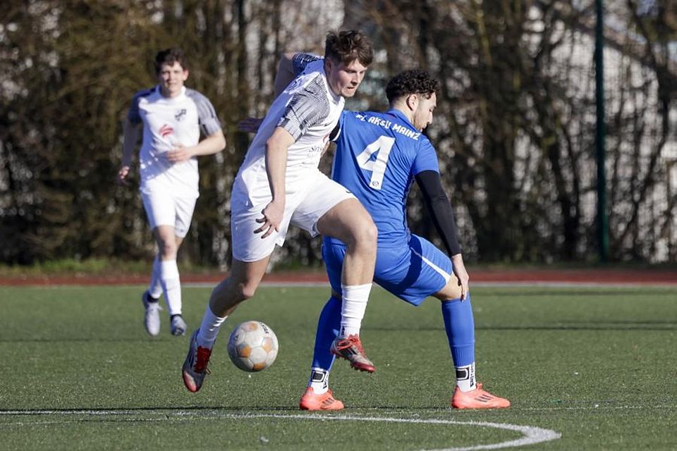 Ober-Olms Vincent Feyerabend (in Weiß) läuft Ilias Kuntich vom FC Aksu davon.	Foto: Stefan Sämmer