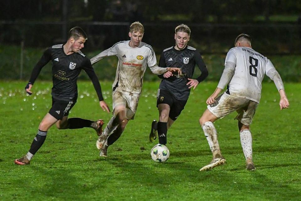 Kräftig durchnässt und vermatscht waren die Landesliga-Kicker des SV Winterbach (schwarze Trikots) – hier mit Elias Pfenning (links) und Leon Zimmermann sowie der SG Meisenheim um Noel Eckel (rechts) und Filip Höft im Derby.	