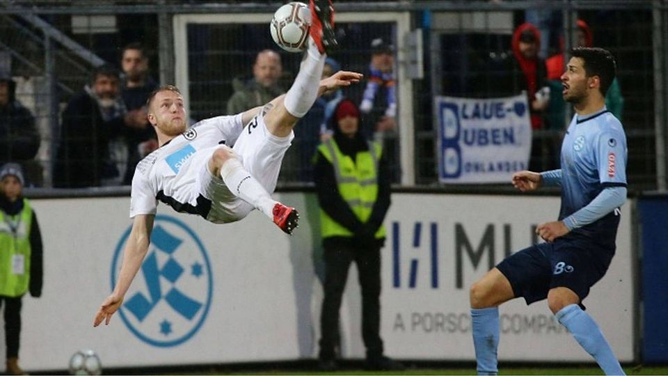 Der Ulmer Steffen Kienle akrobatisch, Kickers-Spieler Edwin Schwarz staunt. Foto: Pressefoto Baumann
