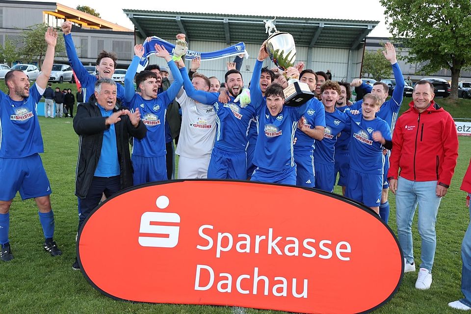 Imposante Trophäe: ASV-Kapitän Niklas Kiermeir stemmt den Pokal in die Höhe, seine Teamkollegen finden‘s prima.