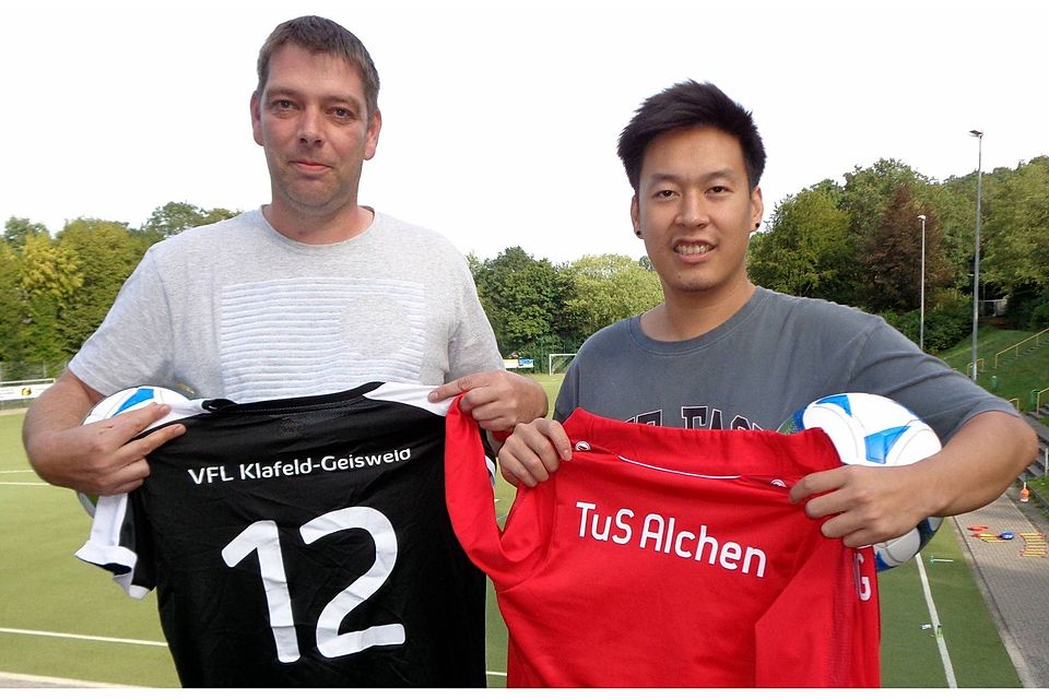 Heiko Röcher (links) vom TuS Alchen und Trung Vu vom VfL Klafeld-Geisweid bezeugen die neue Jugendspielgemeinschaft mit einem Trikot des jeweiligen JSG-Partners. 