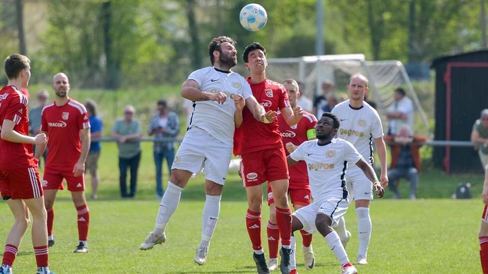Augen zu und durch: TuS-Torschütze Mikheili Kopaliani (links) im Kopfballduell mit dem Nieder-Olmer Marc Kartono Ortiz. Ihre Mitspieler beobachten den Zweikampf.	Foto: Martin Hartmann/pakalski-press