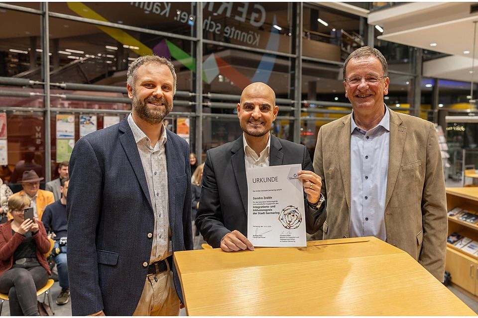 Bei der Preisverleihung in der Stadtbibliothek Germering: Integrationsreferent Christian Huber (l.) und Oberbürgermeister Andreas Haas (r.) überreichen Sandro Zedde (Mitte) den Inklusionspreis für sein großes Engagement.