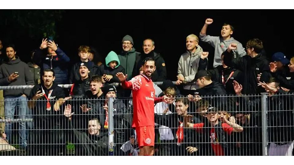 Yunus Malli lässt sich nach dem 2:1-Sieg der U23 von Mainz 05 beim TSV Schott auf dem Zaun von den Fans feiern.