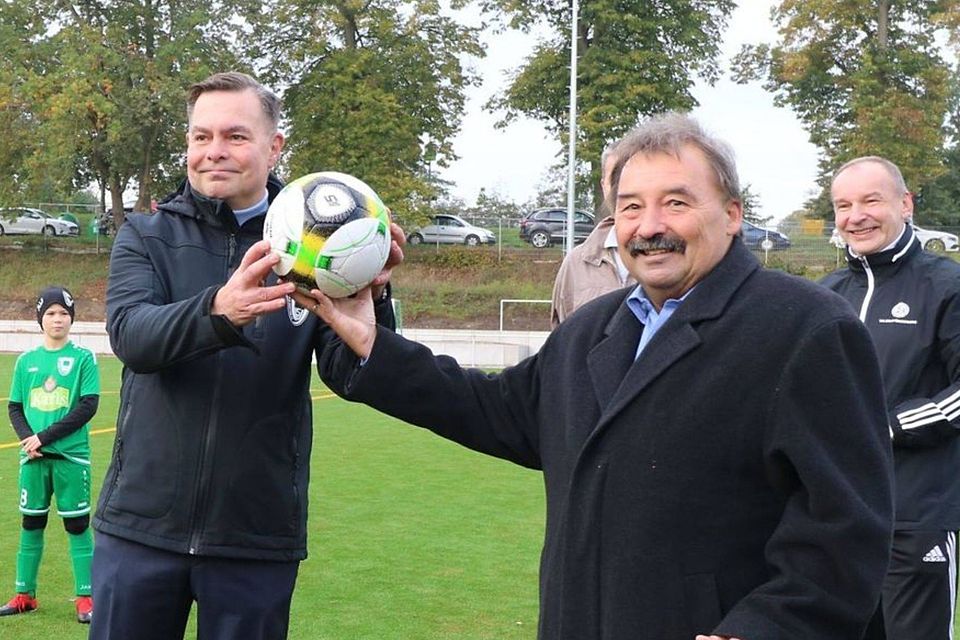 Bürgermeister Jürgen Hemberger übergibt symbolisch einen Ball an den Vorstandsvorsitzenden des SV Dallgow, Markus Rohrbeck.