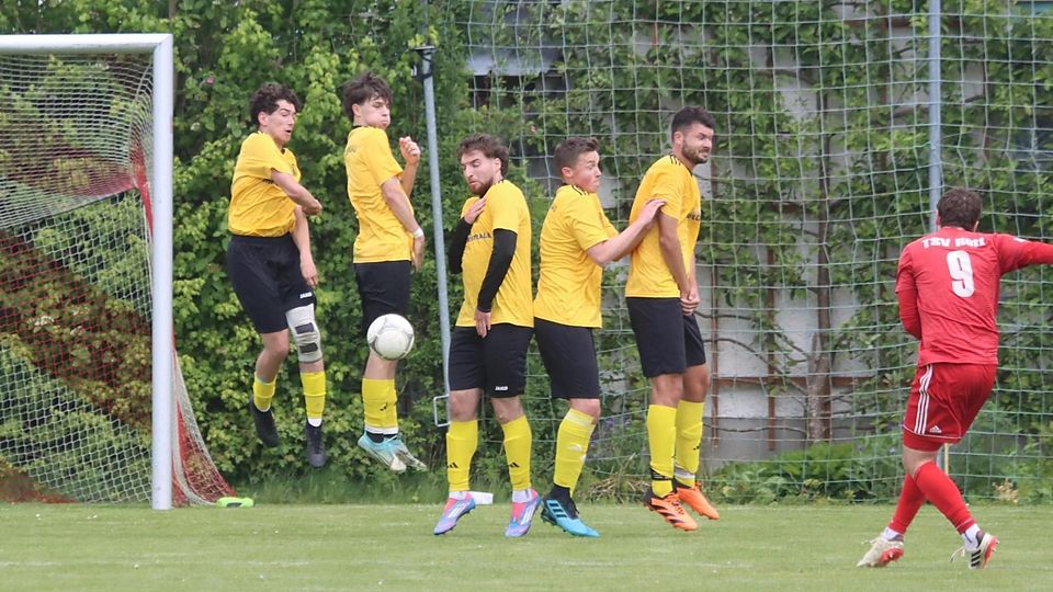 Fußball Saison 2024/25 A-Klasse Jonas Rankl vom TSV Rott (in Rot) schießt 1m 18. Mai 2025 einen Freistoß in die Mauer des TSV Schongau
